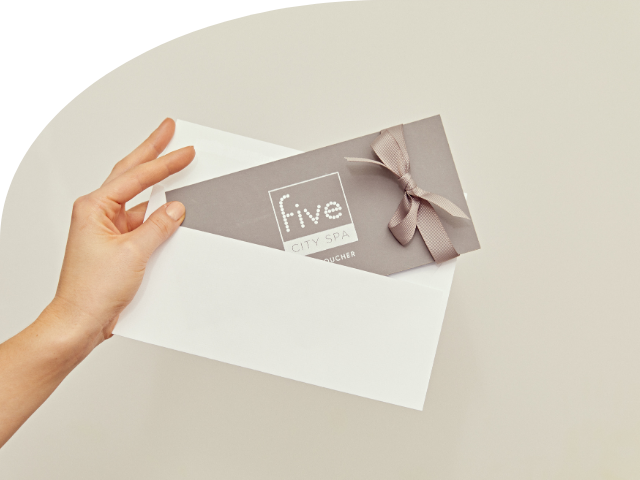 Een hand die een five city spa voucher vasthoudt